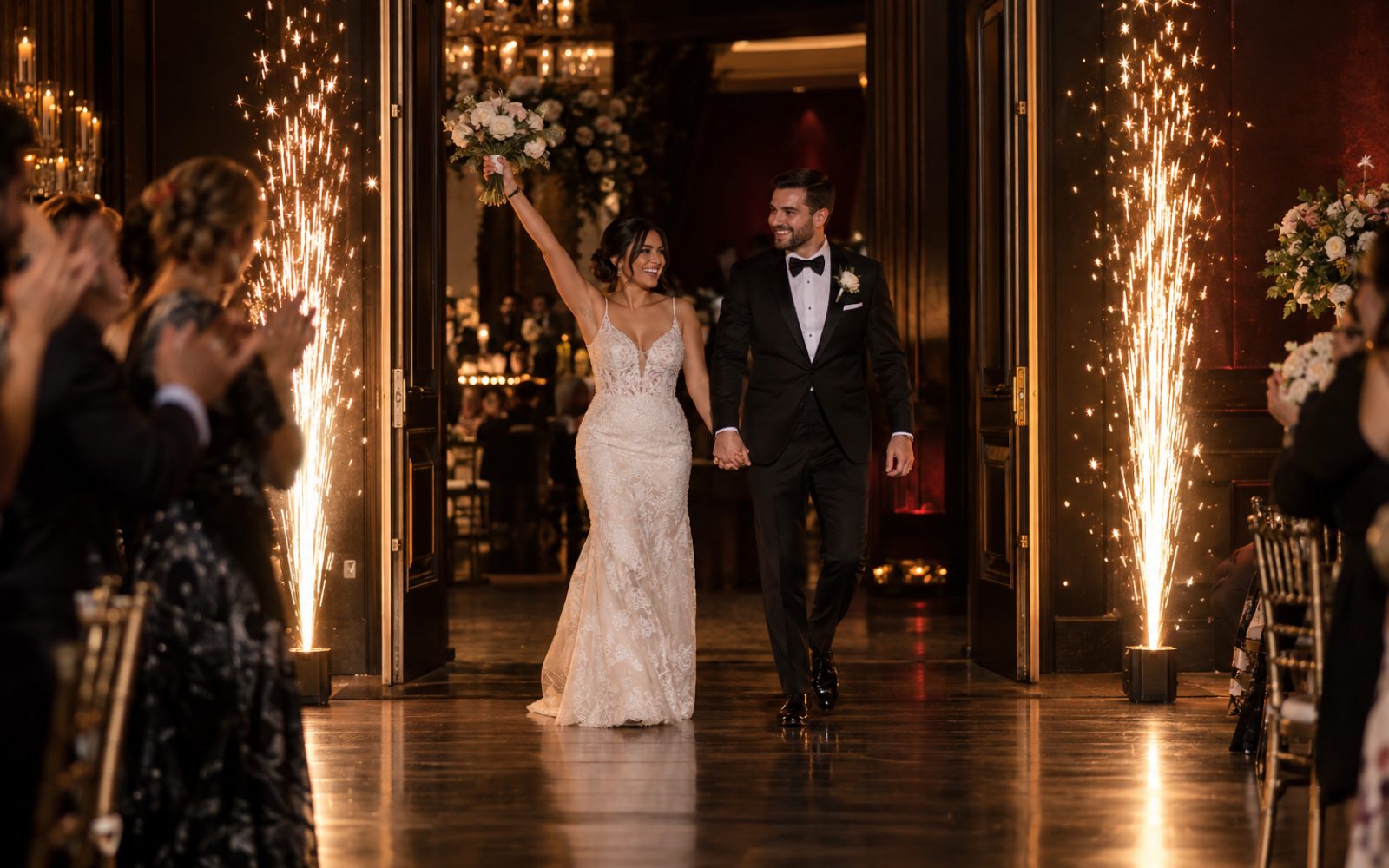 Novios entrando al salón entre dos fuentes de chispa